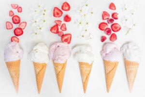 What's the most popular ice cream flavour image 1 jpeg 6 cones laid out with pink and white ice cream scoops with fresh strawberries and flowers white background frosted fusions