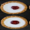 Cherry-Bakewell-Bliss-A-Delectably-Classic-Cherry-Bakewell-Homemade-Ice-Cream-featured-image-201x615w-jpeg-6-cherry-bakewells-lined-up-dark-background-frosted-fusions