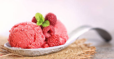 Berrylicious Homemade Raspberry Sorbet image 3 jpeg 2 scoops of Raspberry sorbet on metal spoon with fresh raspberries and sprig of mint frosted fusions