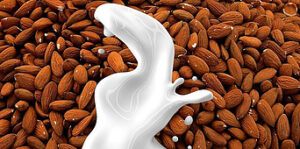 dairy-free-delights-creating-rich-homemade-vegan-ice-cream-image-6-pile-of-fresh-almonds-with-a-splash-of-almond-milk-frosted-fusions