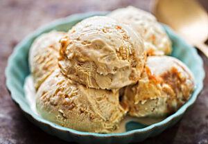 salivate-over-the-irresistible-charm-of-salted-caramel-ice-cream-image-2-jpeg-salted-caramel-ice-cream-in-green-dish-gold-spoon-in-background-frosted-fusions