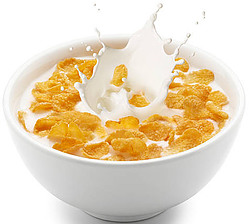 A Homemade Crunchy Cornflake Ice Cream Recipe image 2 white bowl of cornflakes with milk splashing white background frosted fusions