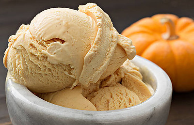 Autumnal Perfection Homemade Pumpkin Ice Cream Recipe image 4 marble dish of pumpkin ice cream with pumpkin in background frosted fusions