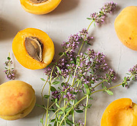 Deliciously Refreshing Homemade Apricot and Thyme Ice Cream Recipe image 4 Apricots scattered some halved and sprigs of flowering thyme frosted fusions