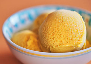 Deliciously Refreshing Homemade Apricot and Thyme Ice Cream Recipe image 5 Apricots bowl of apricot ice cream Orange background frosted fusions