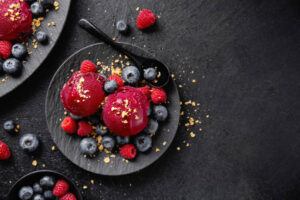 A-Refreshing-and-Healthful-Homemade-Blueberry-Sorbet-image-8-blueberry-sorbet-served-on-a-black-dish-with-fresh-blueberries-scattered-top-view-black-background-frosted-fusions