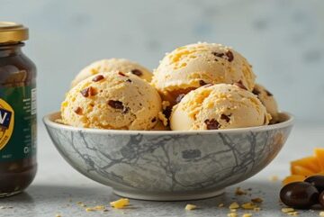 Homemade-Cheese-and-Pickle-Ice-Cream-A-Uniquely-Unconventional-Fusion-featured-image-637x1920w-bowl-of-cheese-and-pickle-ice-cream-with-jar-of-branston-pickle-and-sliced-cheese-frosted-fusions