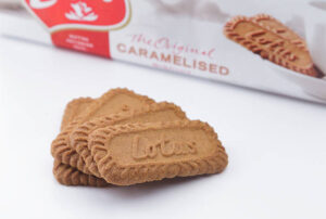 Churn Up the Fun Homemade Biscoff Ice Cream image 1 lotus biscuits stacked on white surface with packet of lotus biscuits in background frosted fusions