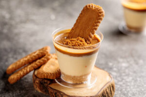 Churn Up the Fun Homemade Biscoff Ice Cream image 2 biscoff biscuits with a glass of coffee dessert one biscuit dunked in dessert frosted fusions 