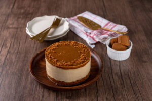 Churn Up the Fun Homemade Biscoff Ice Cream image 8 Biscoff ice cream sandwich with biscoff biscuits in the background Frosted Fusions