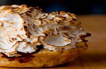Homemade Baked Alaska Its the Bomb featured image 200x600w baked alaska on wooden surface frosted fusions