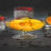 Whip-up-a-Boozy-Homemade-Vodka-and-Orange-Sorbet-featured-image-272x800w-glass-dish-with-scoops-of-orange-sorbet-and-glasses-and-mixers-in-background-frosted-fusions
