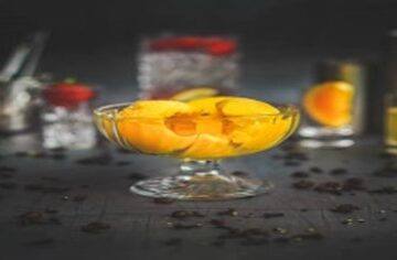 Whip-up-a-Boozy-Homemade-Vodka-and-Orange-Sorbet-featured-image-272x800w-glass-dish-with-scoops-of-orange-sorbet-and-glasses-and-mixers-in-background-frosted-fusions