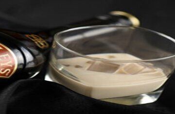 Baileys-and-White-Chocolate-Homemade-Ice-Cream-Boozy-Rich-Indulgence-featured-image-200x600w-bottle-of-baileys-on-side-and-glass-of-baileys-with-ice-dark-background-frosted-fusions
