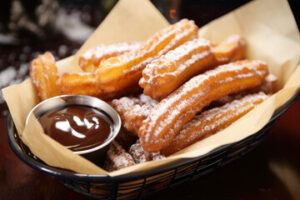 Homemade-Cinnamon-Churros-Ice-Cream-Spice-and-Crispy-Comfort-image-7-tray-of-churros-and-chocolate-sauce-dip-frosted-fusions