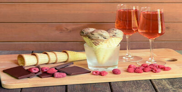 Homemade Champagne and Raspberry Ice Cream Cheers to the New Year image 6 rose champagne in two glasses on wooden board with raspberries ice cream cones and chocolate frosted fusions