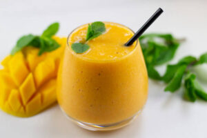 New-Year-Fresh-Vibes-Nourish-Your-Body-With-Healthful-Smoothies-updated-jan25-image-6-mango-smoothie-with-half-a-sliced-mango-frosted-fusions