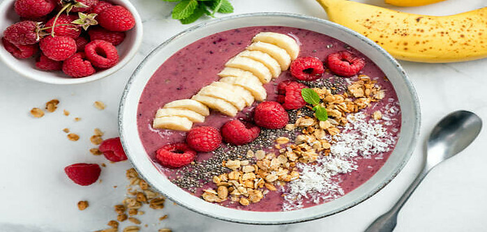 A Delicious And Nutrient-Packed Berry Blast Smoothie image 8 smoothie bowl red smoothie with additiona chopped and sliced fruit and seeds and grains frosted fusions