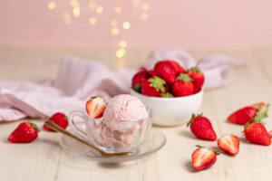 Homemade-Ice-Cream-Treats-For-Valentines-Day-image-13-strawberry-ice-cream-in-glass-dish-with-fresh-strawberries-scattered-frosted-fusions