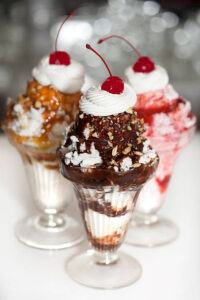 Sweet-Treats-For-Mum-Homemade-Ice-Cream-To-Celebrate-Mothers-Day-image-9-chocolate-fudge-sundaes-topped-with-fresh-cream-chocolate-sauce-drizzled-and-cherries-frosted-fusions