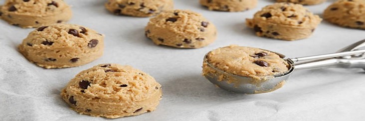 Easy-Homemade-Cookie-Dough-Ice-Cream-Recipe-update-dec24-featured-image-207x620w-cropped-blobs-of-cookie-dough-being-scooped-on-parchmant-paper-for-baking-frosted-fusions