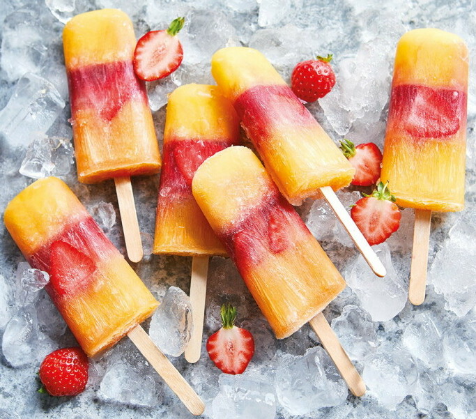 When Life Gives You Lemons Make Homemade Lemonade Ice Lollies image 2 striped fruit lollies with fresh strawberries scattered on ice frosted fusions