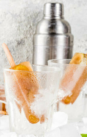 When Life Gives You Lemons Make Homemade Lemonade Ice Lollies image 3 boozy lollies in glasses with cocktail shaker in background frosted fusions