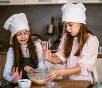 Homemade Honeycomb Ice Cream A Sweet Treat For All Ages image 7 two children with chefs hats and baking equipment smiling whilst mixing frosted fusions