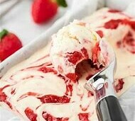 Homemade Strawberry Cheesecake Ice Cream Recipe image 6 strawberry cheesecake ice cream being served in ice cream scoop with fresh strawberries in background frosted fusions