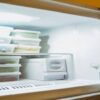 How-Long-Does-Homemade-Ice-Cream-Last-In-Your-Freezer-featured-image-207x620w-several-food-storage-containers-stacked-in-an-open-freezer-frosted-fusions