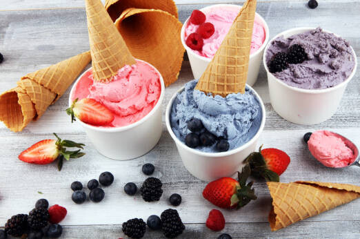The Ice Cream And Sugar Debate image 9 tubs of fresh fruity ice cream with fresh fruits and ice cream cones scattered frosted fusions