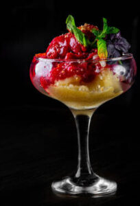 halloween-ice-cream-treats-spooky-ice-scream-recipes-for-the-occasion-image-5-tall-glass-of-blood-roange-sorbet-with-red-sauce-drizzled-all-over-black-background-frosted-fusions