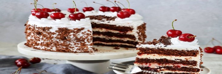 Black-Forest-Ice-Cream-Cake-featured-image-207x620w-black-forest-gateau-on-cake-stand-with-a-slice-cut-out-fresh-cherries-scattered-frosted-fusions