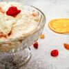Homemade-Cranberry-Orange-Ice-Cream-Recipe-featured-image-207x620w-glass-dessert-dish-with-cranberry-and-orange-ice-cream-with-slices-of-orange-and-scattered-cranberries-to-the-side-frosted-fusions