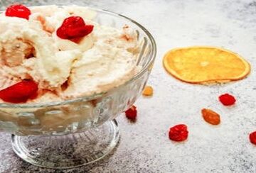 Homemade-Cranberry-Orange-Ice-Cream-Recipe-featured-image-207x620w-glass-dessert-dish-with-cranberry-and-orange-ice-cream-with-slices-of-orange-and-scattered-cranberries-to-the-side-frosted-fusions