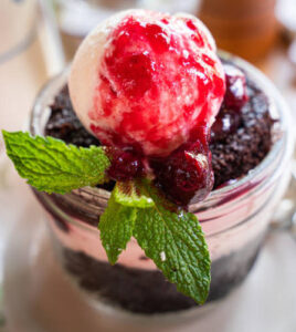 black-forest-ice-cream-cake-image-2-dish-of-black-forest-ice-cream-topped-with-cherry-sauce-and-finished-with-mint-leaves-frosted-fusions