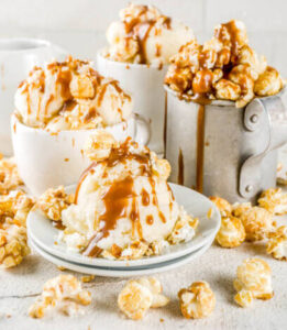 transform-movie-nights-with-delicious-homemade-popcorn-ice-cream-image-5-cups-and-dishes-filled-and-spilling-over-with-ice-cream-popcorn-and-caramel-sauce-frosted-fusions