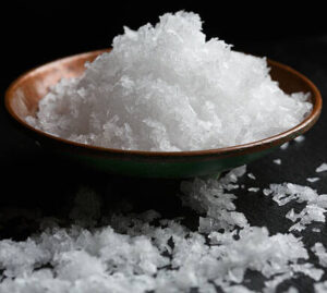 transform-movie-nights-with-delicious-homemade-popcorn-ice-cream-image-8-sea-salt-flakes-on-wooden-bowl-black-background-frosted-fusions