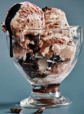 Homemade Chocolate Brownie Ice Cream Recipe image 5 chocolate brownie ice cream sundae with hot fudge sauce dripping frosted fusions