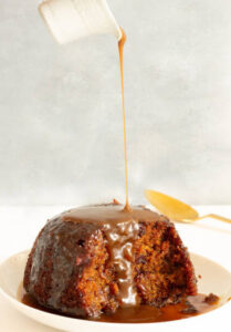how-to-pair-ice-cream-with-classic-christmas-desserts-image-1-sticky-toffee-pudding-with-caramel-sauce-being-poured-onto-it-frosted-fusions