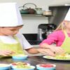 Fun-Easy-And-Healthy-Frozen-Dessert-Recipe-Ideas-For-Kids-featured-image-207x620w-boy-and-girl-in-chefs-hats-and-aprons-with-fresh-ingredients-in-kitchen-setting-frosted-fusions