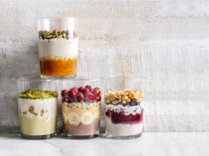 Quick-Easy-And-Deliciously-Healthy-Breakfast-Smoothie-Recipes-image-2-four-smoothie-glasses-filled-with-a-selection-of-different-breakfast-smoothies-and-ingredients-Frosted-Fusions