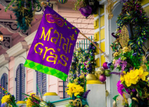 5-Creole-Cajun-Inspired-Ice-Cream-Recipes-To-Jazz-Up-Your-Mardi-Gras-image-11-flag-with-mardi-gras-on-it-in-the-traditional-colours-outside-a-typical-french-quarters-building-Frosted-Fusions