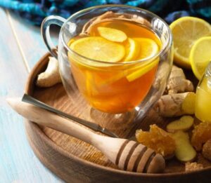 A-Not-So-Hot-Toddy-Homemade-Honey-Lemon-Ginger-Ice-Cream-image-1-glass-of-honey-lemon-and-ginger-with-fresh-ingredients-on-a-tray-Frosted-Fusions