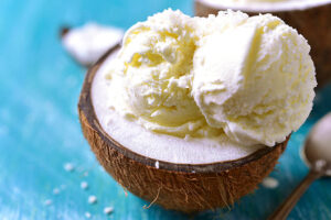 Easy-Homemade-Keto-Ice-Cream-–-A-Delicious-Low-Carb-Recipe-image-4-vanilla-ice-cream-scoops-served-in-a-half-coconut-shell-Frosted-Fusions