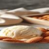 Homemade-Dairy-Free-Almond-Milk-Ice-Cream-Recipe-featured-image-280x1000w-carton-and-glass-of-almond-milk-with-bowl-of-almond-milk-ice-cream-and-fresh-almonds-scattered-around-Frosted-Fusions