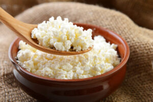 Is-Viral-Cottage-Cheese-Ice-Cream-Worth-All-The-Hype-image-2-wooden-bowl-and-spoon-filled-with-cottage-cheese-Frosted-Fusions