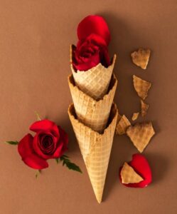 Love-At-First-Scoop-–-Valentines-Ice-Cream-Recipe-Ideas-image-8-ice-cream-waffle-cones-filled-with-red-roses-and-petals-scattered-around-Frosted-Fusions