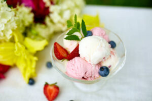 No-Leap-Just-A-Scoop-Ice-Cream-Flavours-To-Spring-Into-March-image-10-glass-dish-of-ice-cream-with-fresh-berries-and-fresh-dlowers-to-the-side-Frosted-Fusions