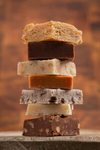 Classic-Fudge-Meets-Chocolate-Fudge-Ice-Cream-–-Trendy-Nostalgia-image-6 stack of different styles of fudge Frosted-Fusions